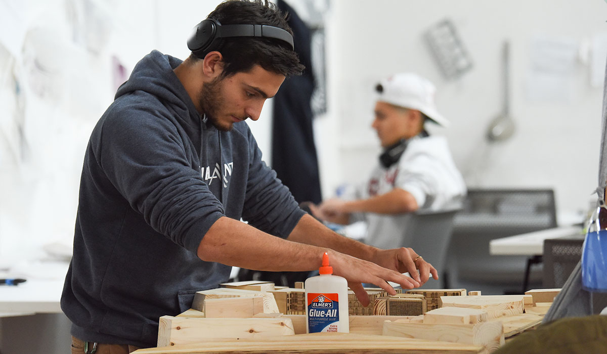 Second mosaic photo shows a male architecture student assembling a model using wood and glue