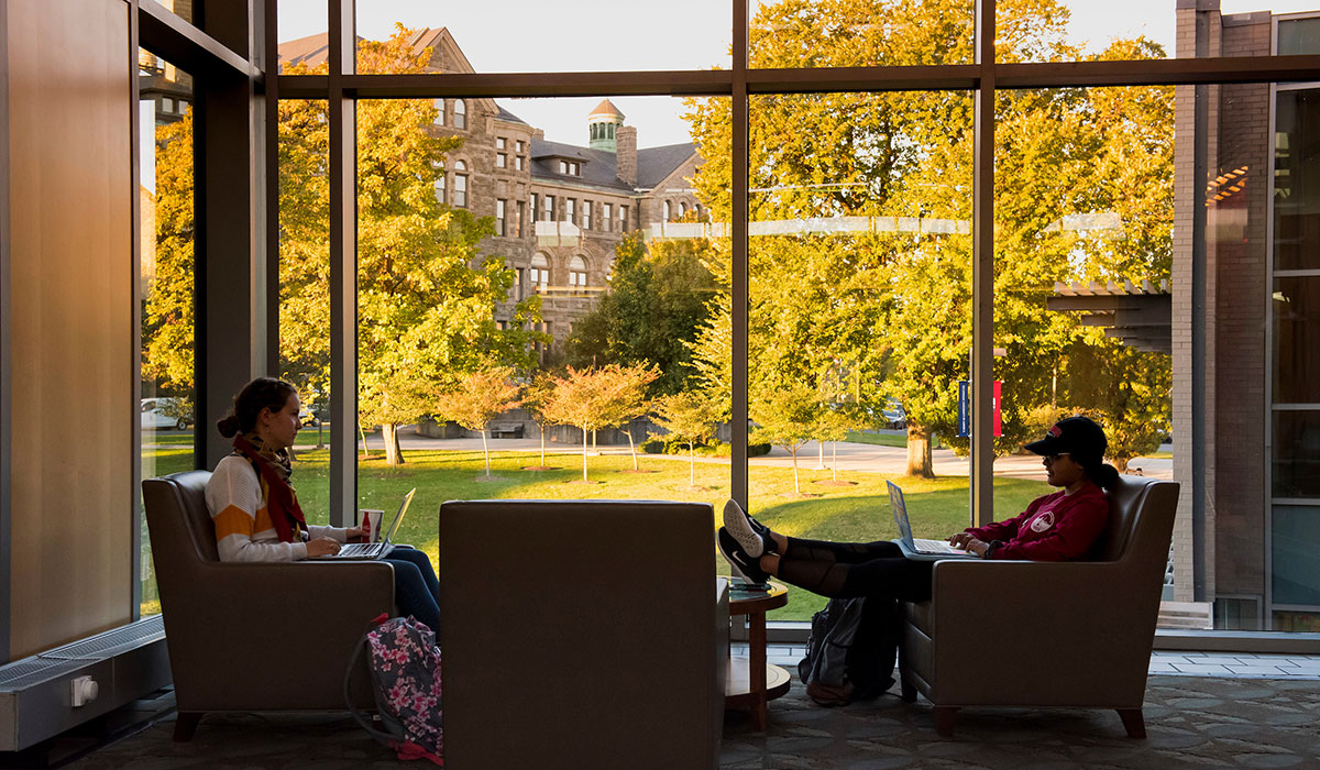 Fourth mosaic photo shows students sitting in comfortable chairs in the gallery area of the Pryz with a sunlit fall campus scene through the windows behind them.