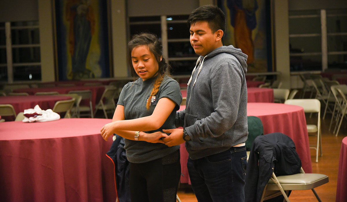 First mosaic photo shows a male student and female student practicing a dance in Caldwell auditorium