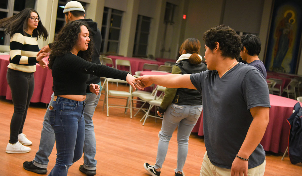 Third mosaic photo shows shows six students practicing a dance in Caldwell auditorium.