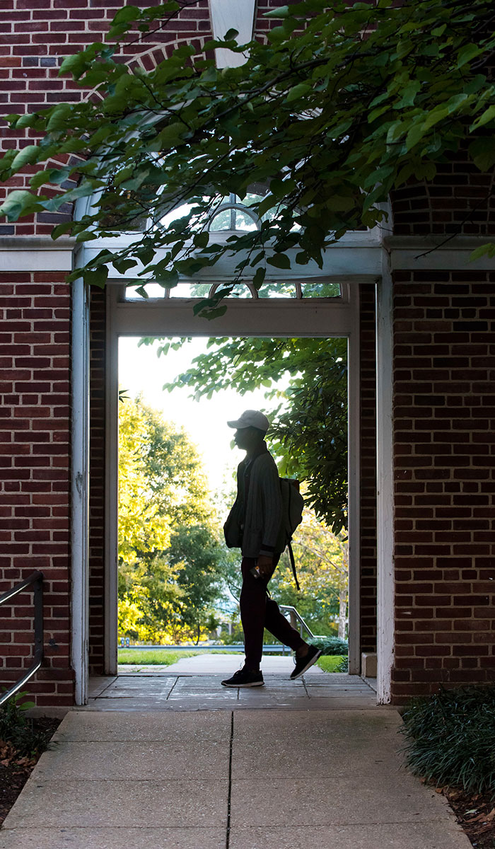 Third mosaic image shows a male student passing through archway between a residence hall on St. Vincent's Chapel.